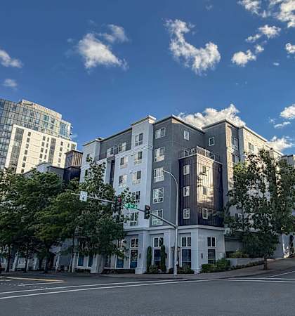 A street view of a white building with a green traffic light.