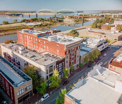 A cityscape with a river and a bridge in the background.