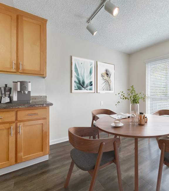 a dining room with a table and chairs and a kitchen  at Pleasanton Glen Apartments, California, 94566