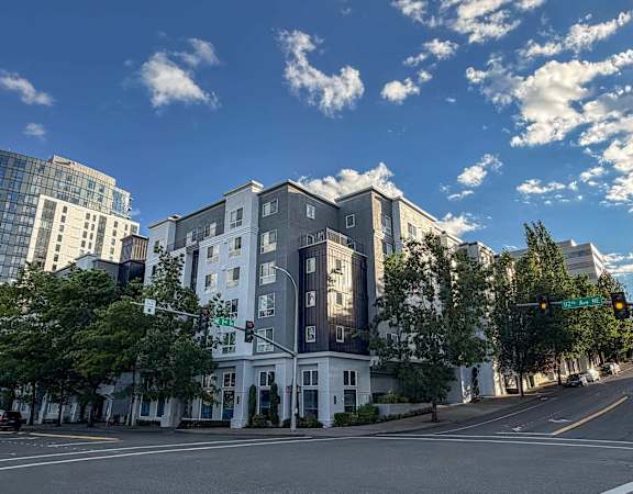 A street view of a white building with a green traffic light.