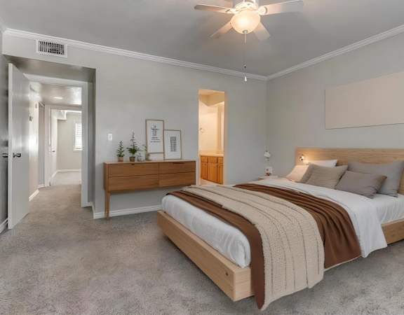 A bedroom with a large bed and a ceiling fan.