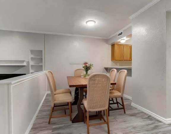 A dining room with a table and chairs.