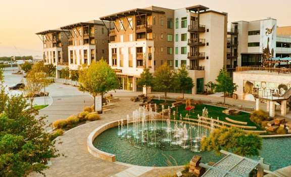 a view of a fountain in front of an apartment building