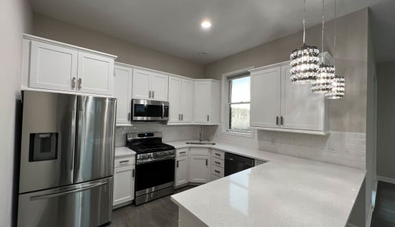 a kitchen with white cabinets and stainless steel appliances