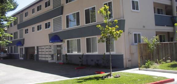 a large apartment building with a sidewalk in front of it