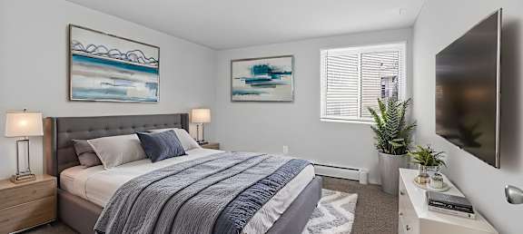 A bedroom with a large bed and a painting on the wall.