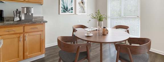 a dining room with a table and chairs and a kitchen  at Pleasanton Glen Apartments, California, 94566