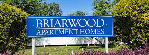 A blue sign that says Briarwood Apartment Homes.