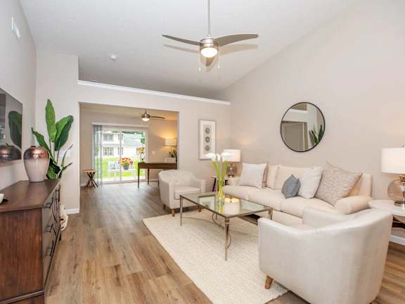 A living room with a white couch and a ceiling fan.