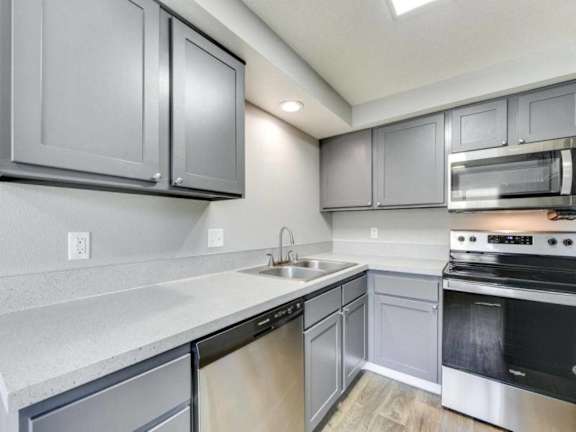 a kitchen with stainless steel appliances and white counter tops