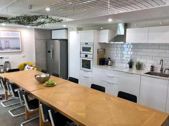 a kitchen with white cabinets and a wooden table