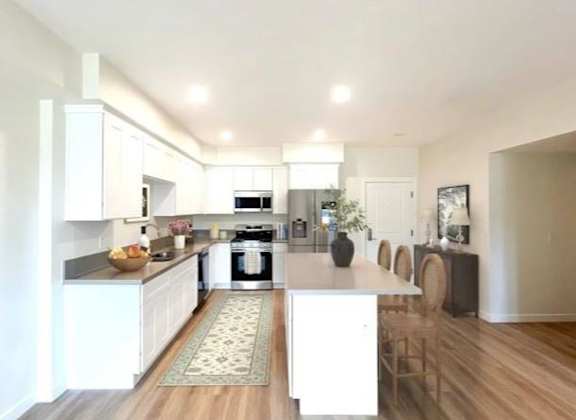 A modern kitchen with white cabinets and a center island.