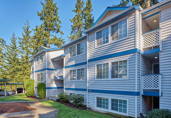 blue and white apartment buildings with a walkway and grass