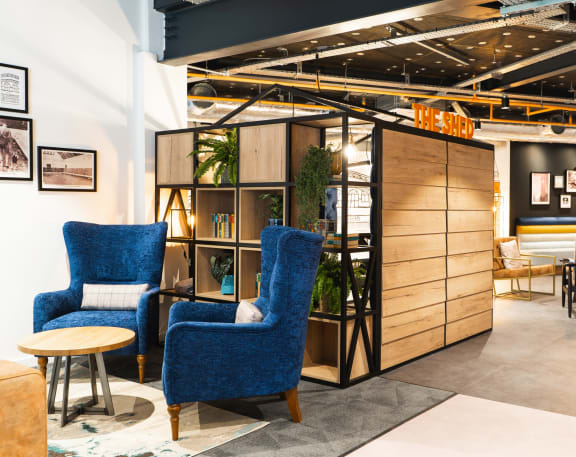 a lobby with two blue chairs and a wooden cabinet