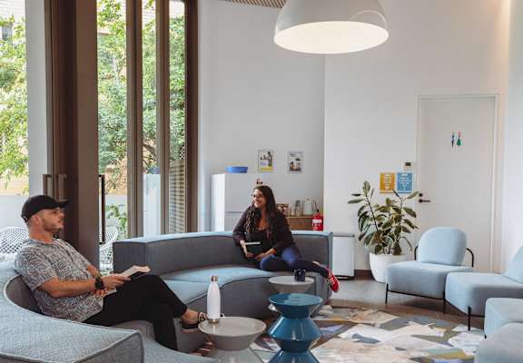 two people sitting on couches in a living room