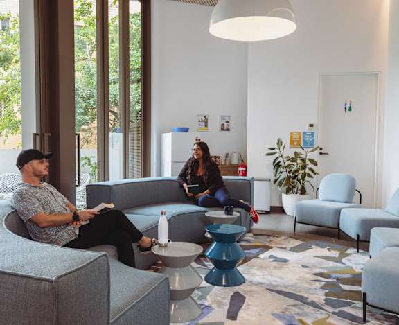 two people sitting on couches in a living room