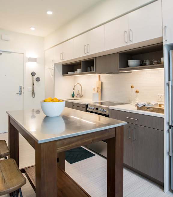 A modern kitchen with a wooden table and chairs. at The Union Flats, Union City