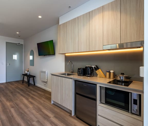 a kitchen with a sink and a stove and a tv