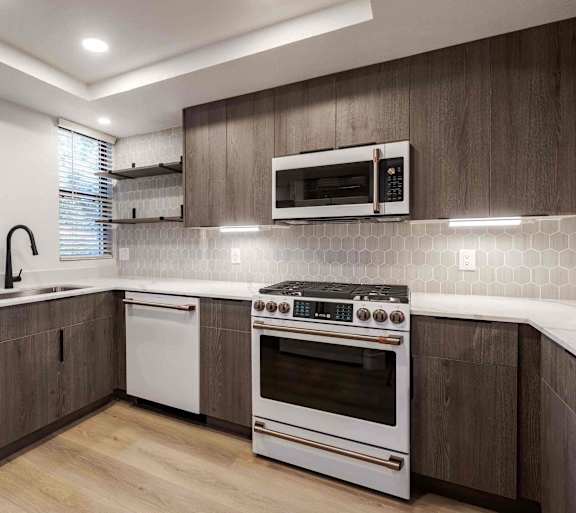 A modern kitchen with a white oven and microwave above it.
