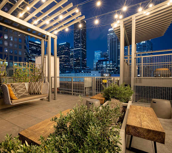 A rooftop patio with a view of the city at night.