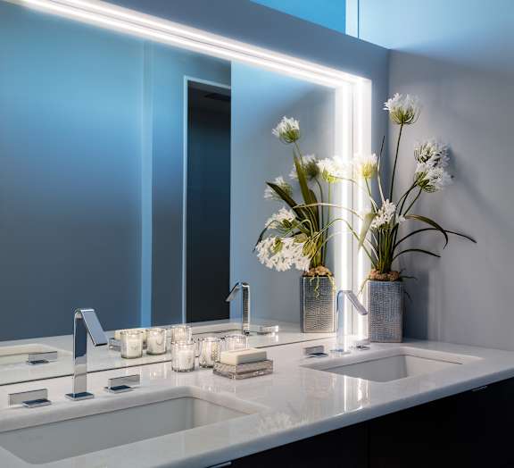 A modern bathroom with a white sink and a large mirror at Residences Providence, Providence, 2903