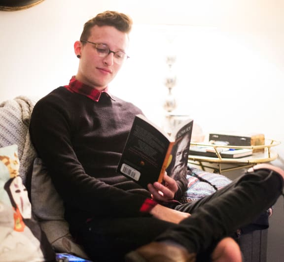 a man sitting in a chair reading a book