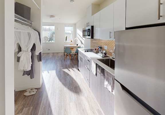 a kitchen with stainless steel appliances and white cabinets at Enve, Seattle, WA 98102