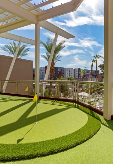 a putting green on a balcony with a pool