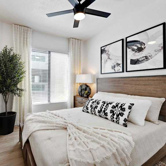 A bedroom with a large bed and a ceiling fan.
