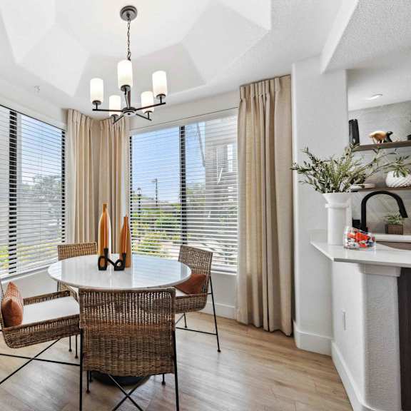 A dining room with a white table and chairs.