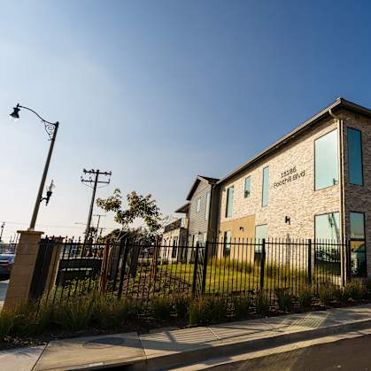 A modern house with a black fence in front of it.