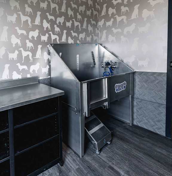 A kitchen with a wallpaper of dogs on the wall.