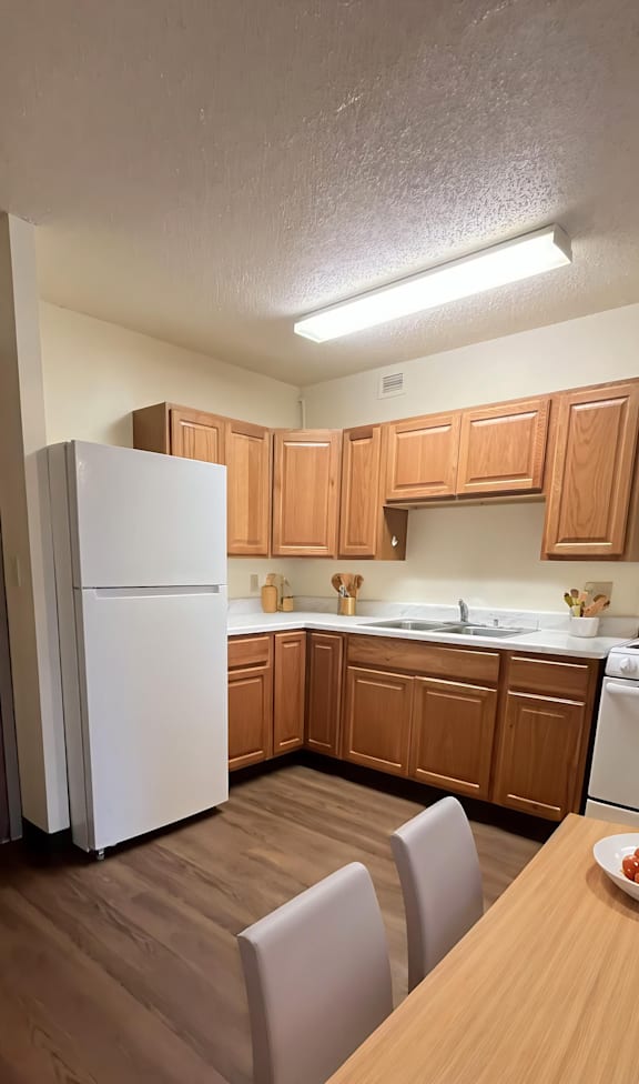 A kitchen with wooden cabinets and a white refrigerator.