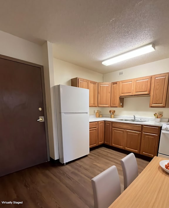 A kitchen with wooden cabinets and a white refrigerator.