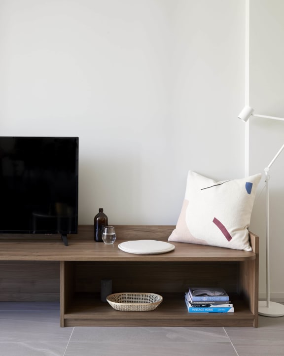 a bench with a pillow and a tv on it