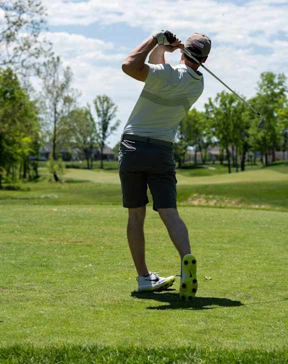 A man is playing golf on a sunny day.