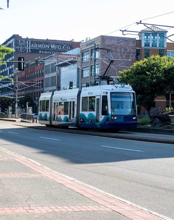 A train is on a track in the middle of a city street.