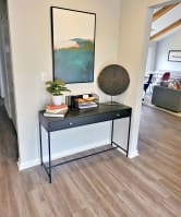 a living room with a table and a painting on the wall