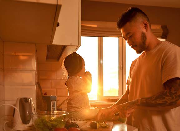 A man and a woman are preparing food in a kitchen.