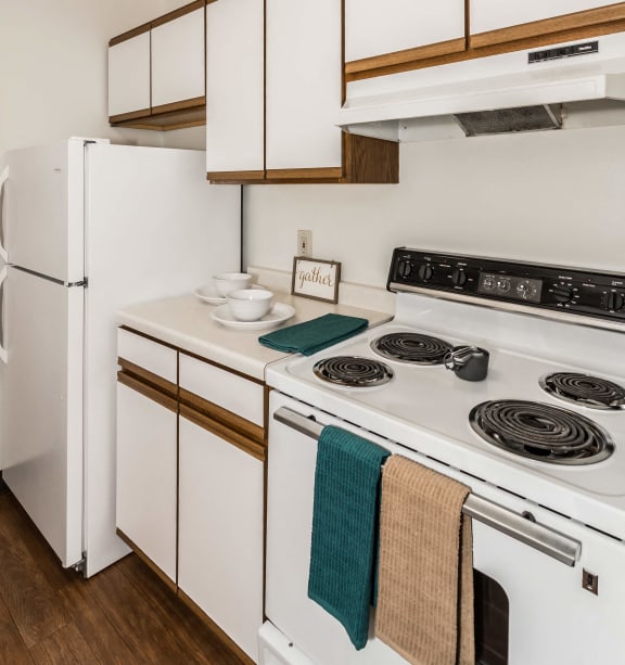 Bismarck, ND Stonefield Townhomes | Dining Room Grand Forks, ND Bristol Park Apartments. a kitchen with white appliances and white cabinets