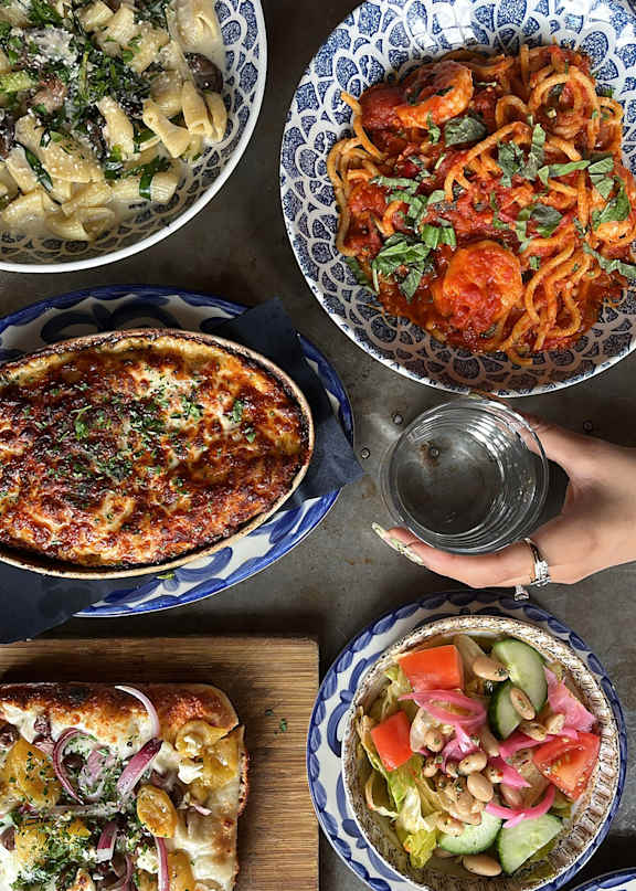 A variety of dishes are served in blue and white patterned bowls.