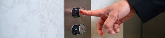 A person is pressing a button on a control panel.
