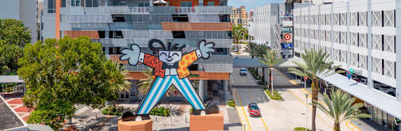 A large statue of a man with a guitar stands in front of a building.