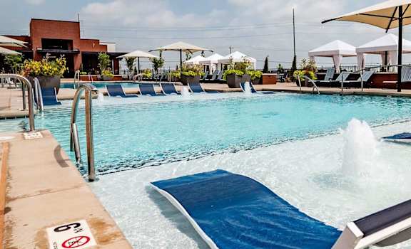 A pool with a blue mat and a white umbrella.