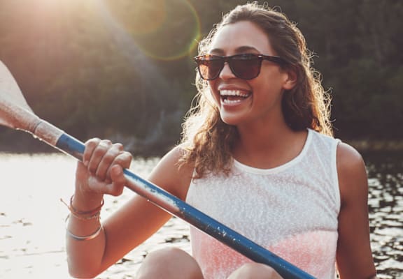 A woman is paddleboarding on a lake.