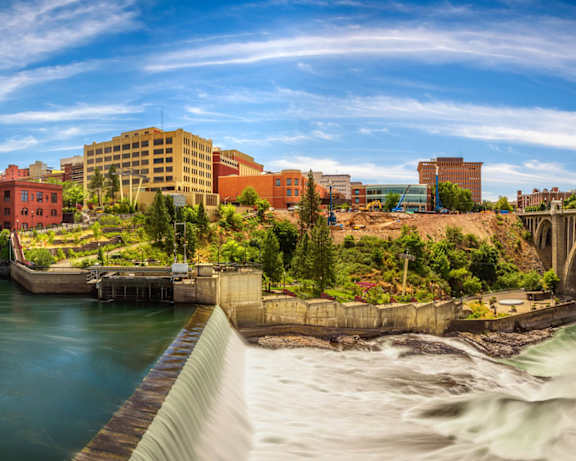 A river flows through a city with a bridge crossing over it.