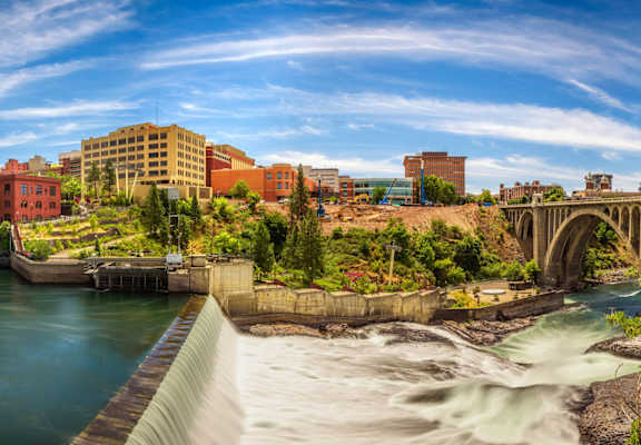 A river flows through a city with a bridge crossing over it.