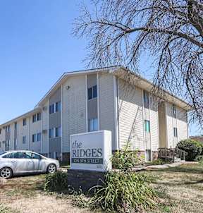 residential building with a parking lot in front at The Ridges Apartments, Des Moines, IA