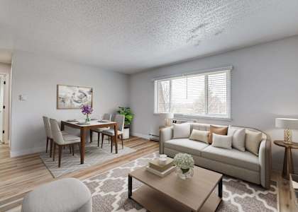 A well-lit living room with a dining table and a couch at The Hampton Meadows Apartments, Iowa, 50315