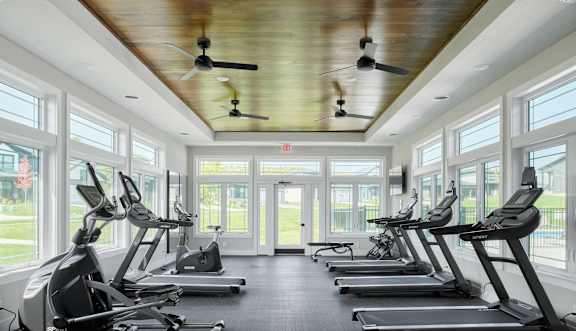 A gym with treadmills and a ceiling fan.